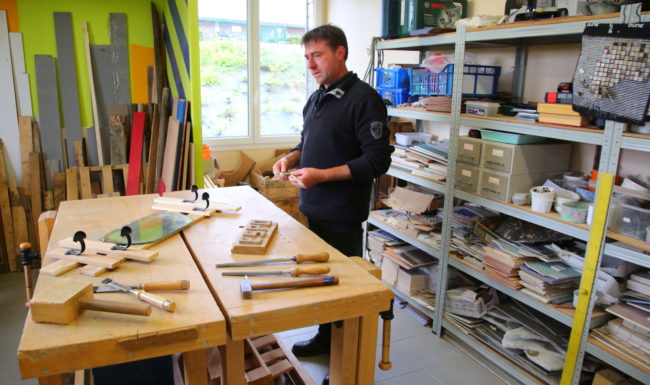 Atelier bois du centre, avec l'éducateur devant un établi et des outils