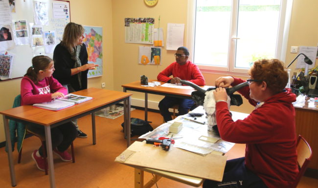 salle de classe avec une éducatrice et 3 élèves